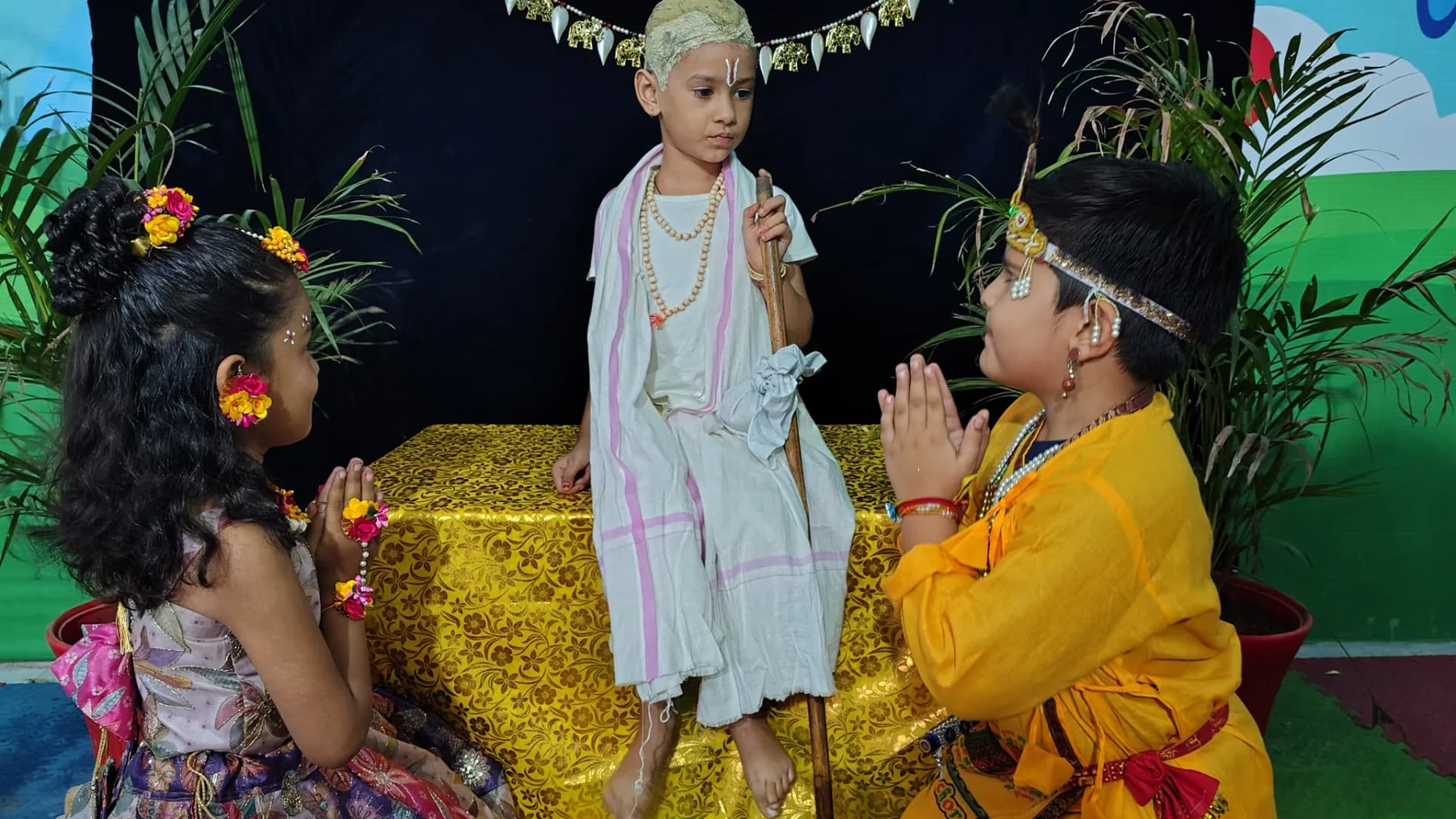 Students presenting a Janmashtami scene on stage